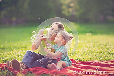 Happy Childhood â€“ Mother and child blows soup foam and make bubbles Stock Photo